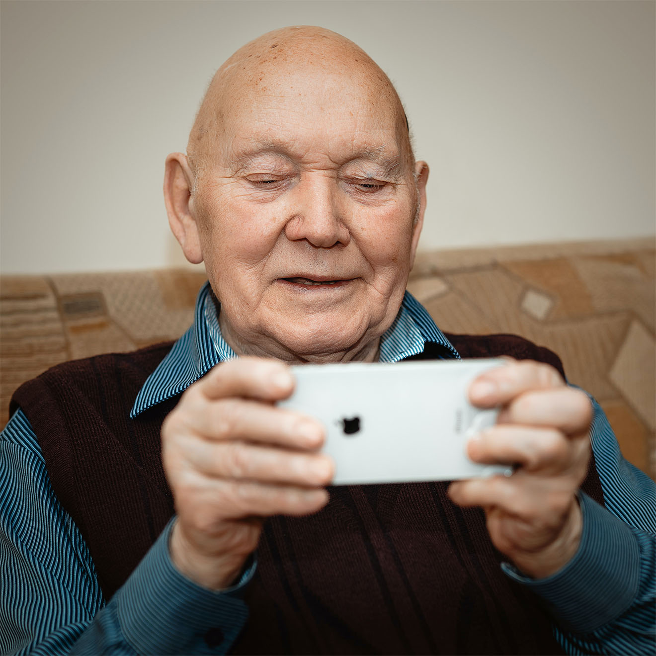 male resident playing a game on a phone smiling