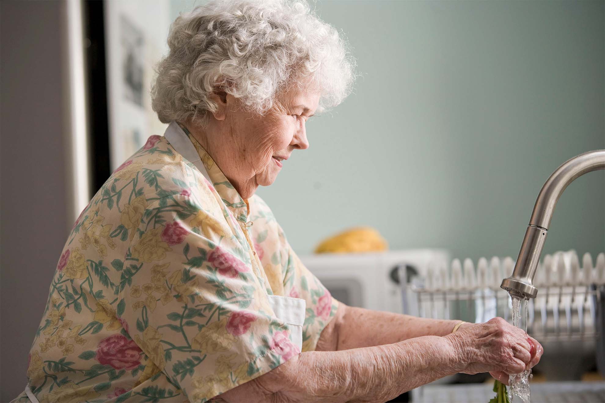 older woman washing vegetables ready for dinner
